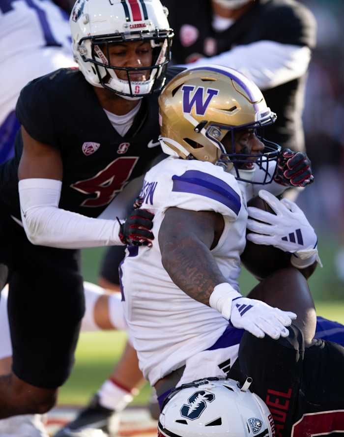 Oct 28, 2023; Stanford, California, USA; Washington Huskies running back Dillon Johnson (7) is wrapped up by Stanford Cardinal cornerback Zahran Manley (4) and inside linebacker Gaethan Bernadel (0) on a run from scrimmage during the first quarter at Stanford Stadium. Mandatory Credit: D. Ross Cameron-USA TODAY Sports